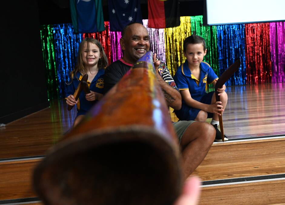 Richard Clarke from Social Futures shows Scarlett Duroux, 6, and Eric Dann, 6, how to play a didgeridoo at Lismore Public School. Picture by Cathy Adams